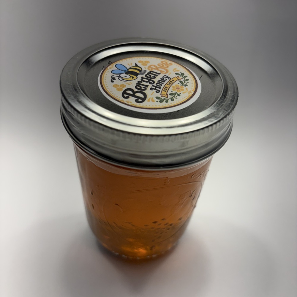 Eight-ounce jar of Bergen Bee raw honey produced through local colony work